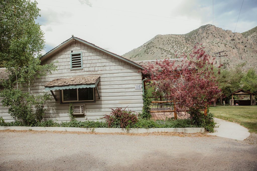 A small white house with mountains in the background