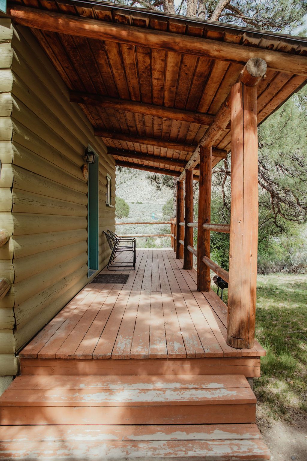 A log cabin with a porch and stairs leading to it.