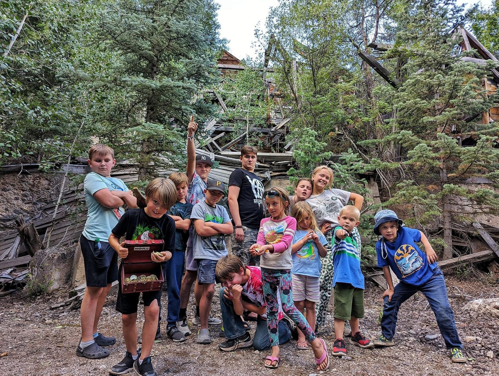 A group of children are posing for a picture in the woods.