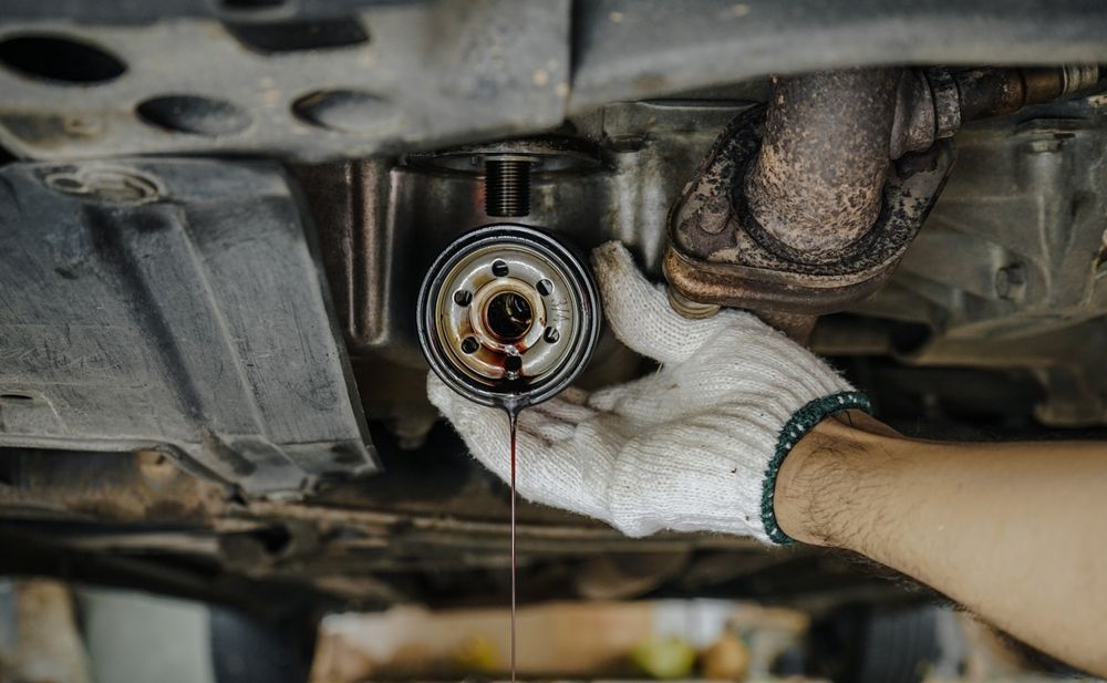 A person is changing the oil filter on a car.