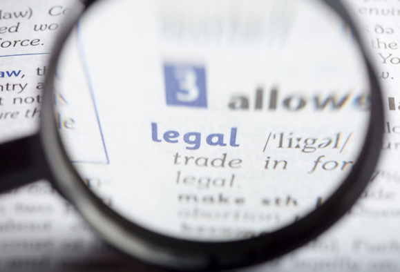 A magnifying glass is focused on the word legal