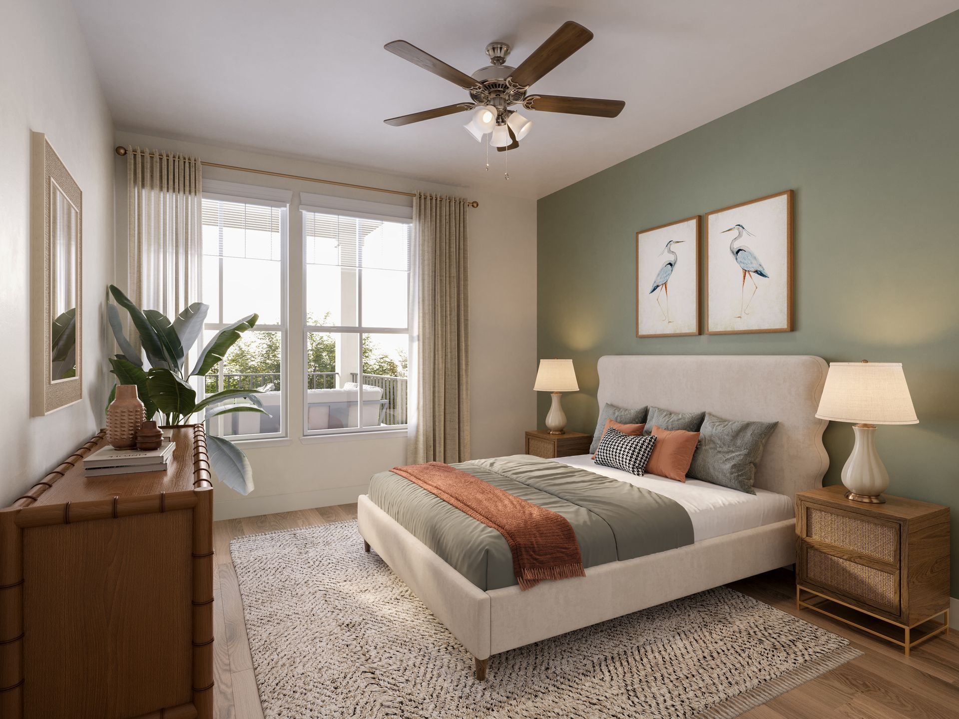 A bright, modern bedroom with sage green accent wall, white bed with orange throw, and wooden furniture.