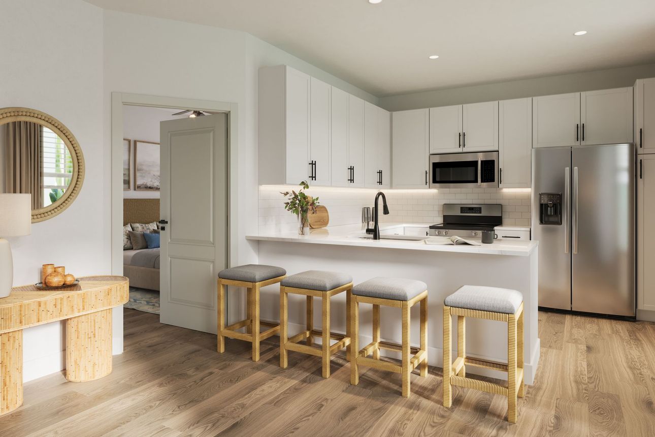 Modern kitchen with white cabinets, stainless steel appliances, a breakfast bar with four stools, and a wood console table.