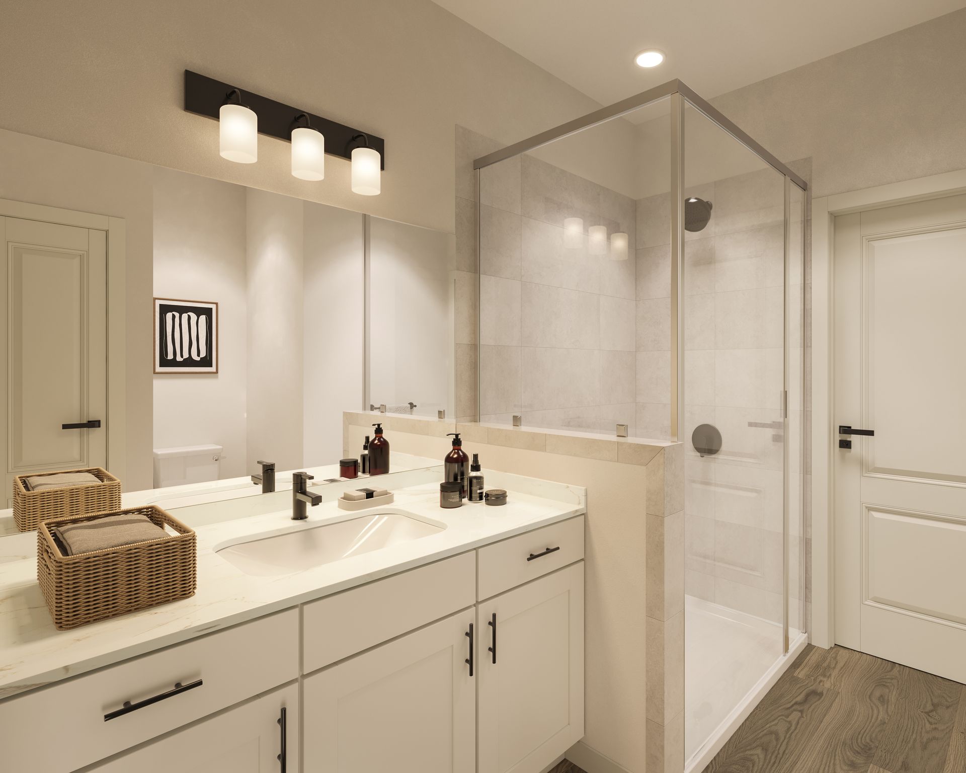 A modern, brightly lit bathroom with a white vanity, a glass shower stall, and a framed piece of wall art.