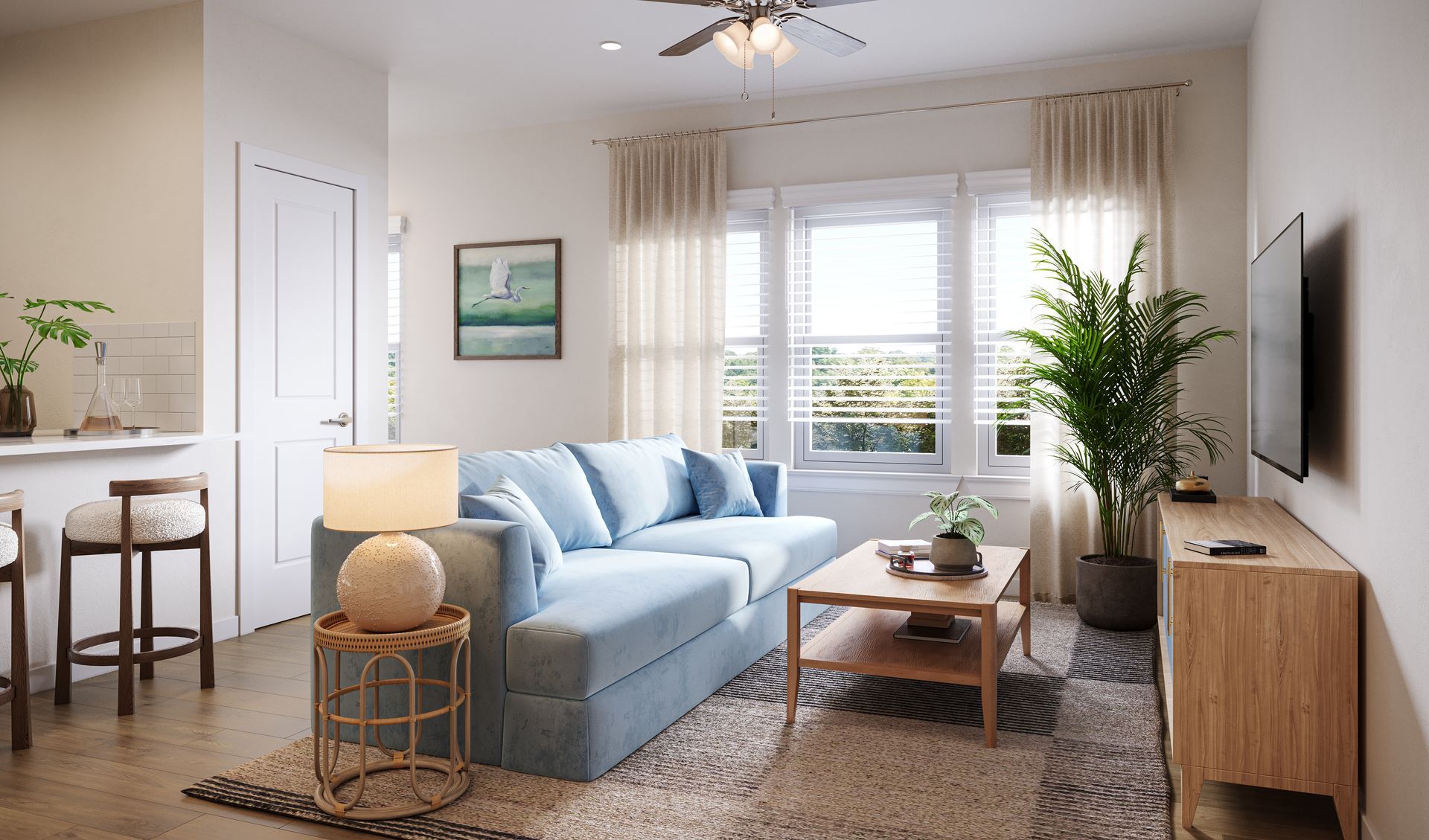 A light blue sofa, wood coffee table, and large potted plant in a bright living room with neutral decor.