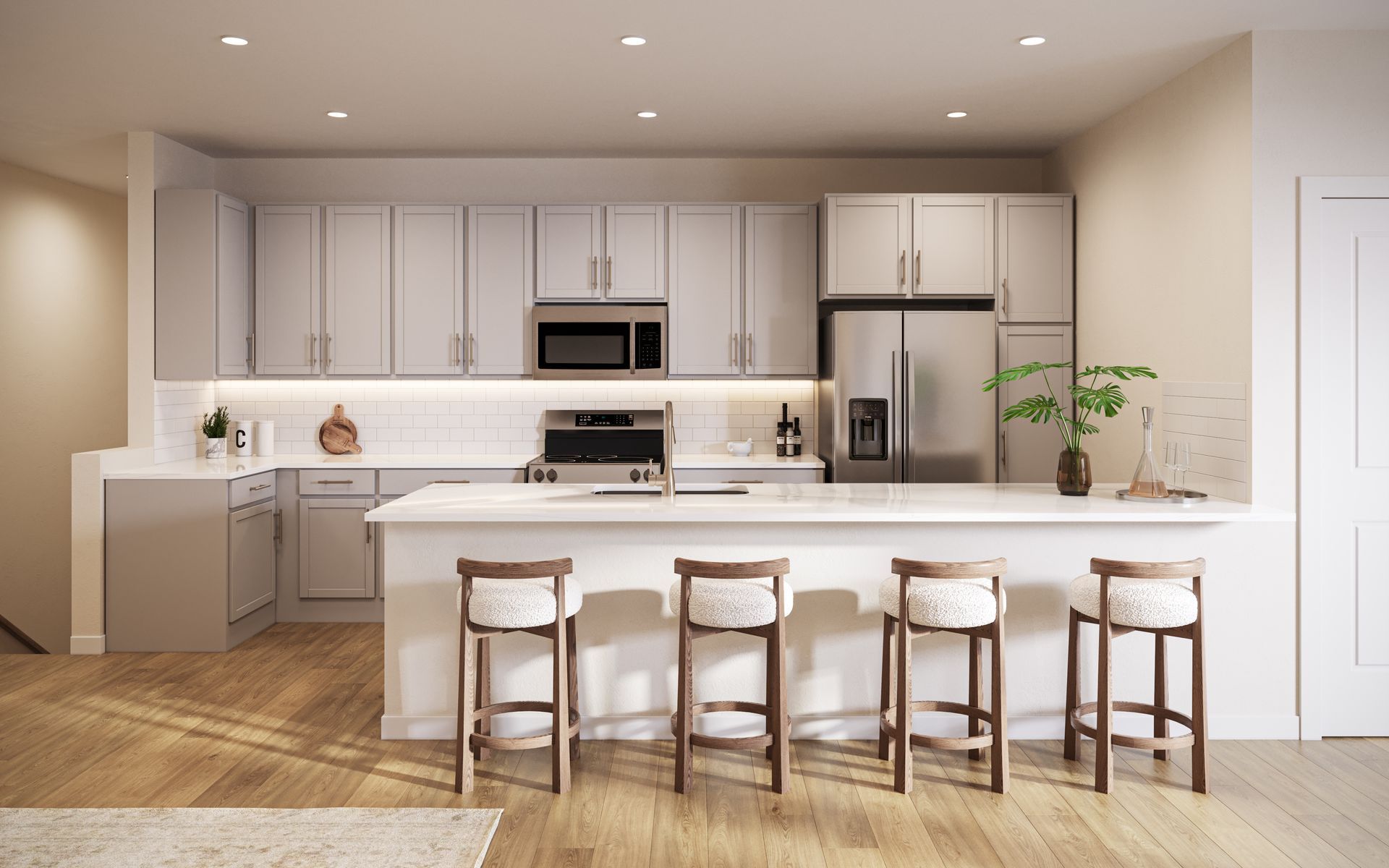Modern kitchen with light gray cabinets, stainless steel appliances, a white island with four wooden stools, and wood floor.