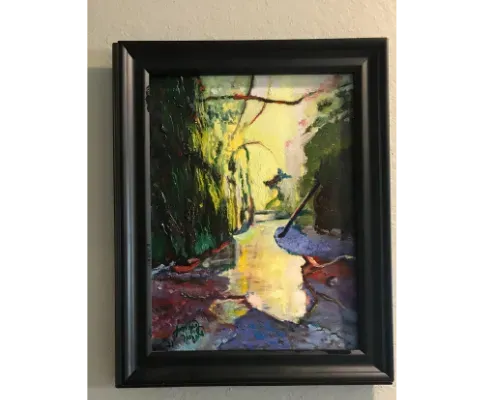 An impressionist painting in a black frame depicts a sunlit stream flowing through a lush, vibrant green forest.