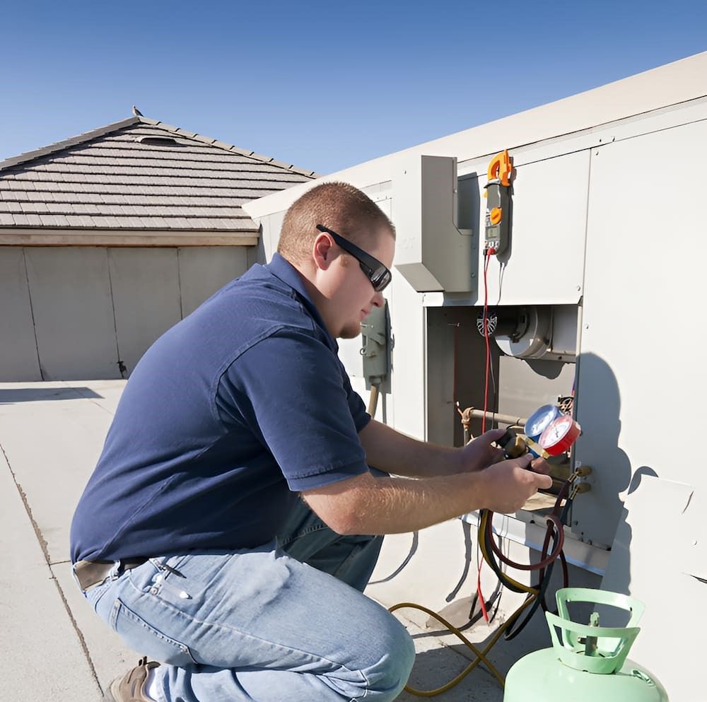 A Man Is Working On An Air Conditioner — BT Airconditioning In Gordonvale, QLD