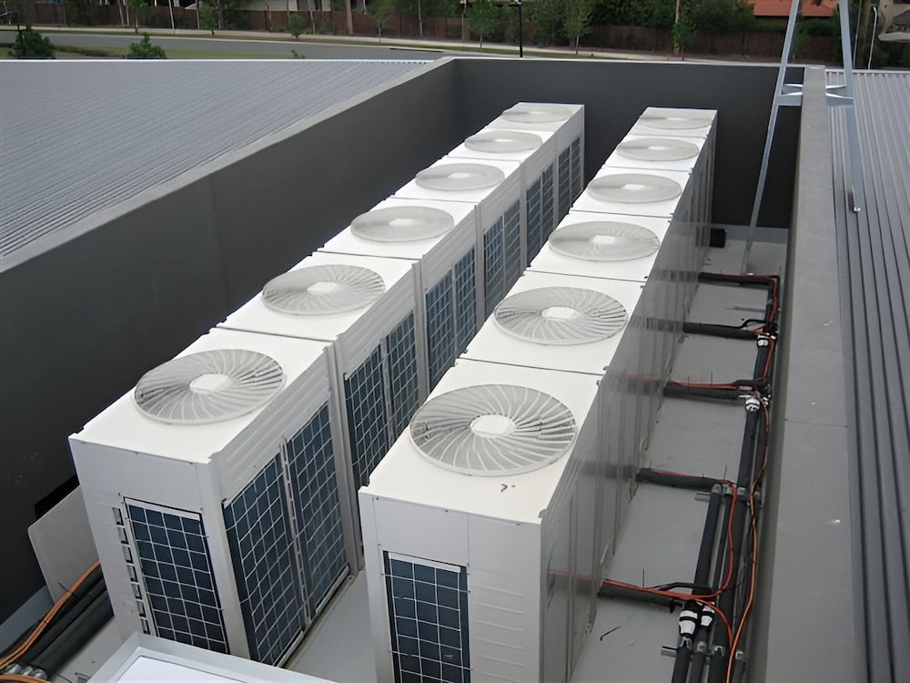 A Row Of Air Conditioners On Top Of A Building — BT Airconditioning In Portsmith, QLD