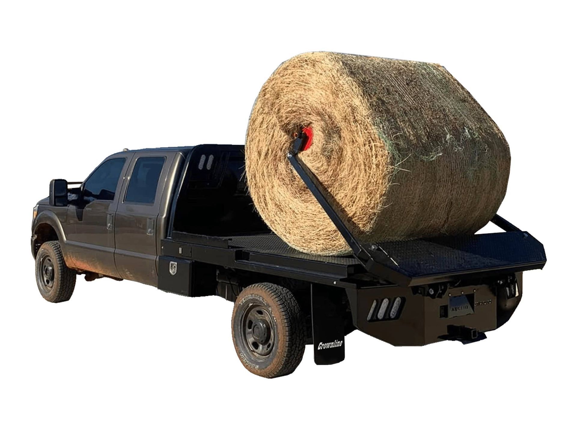 A large bale of hay is sitting on top of a flatbed truck.