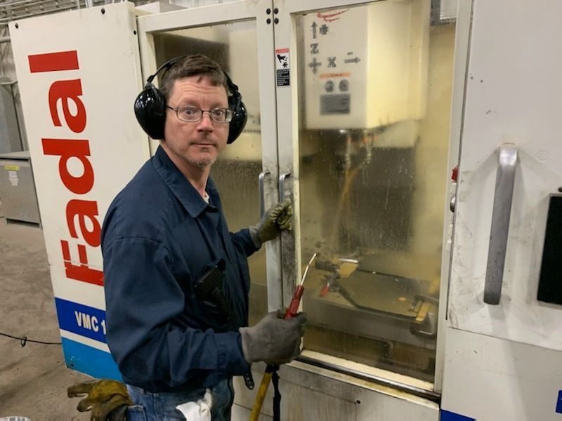 image of man standing by production fabrication machine