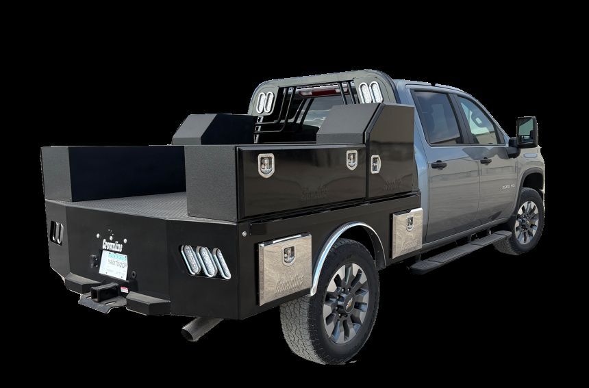 Black pickup truck with custom utility bed, side toolboxes, and tow hitch.