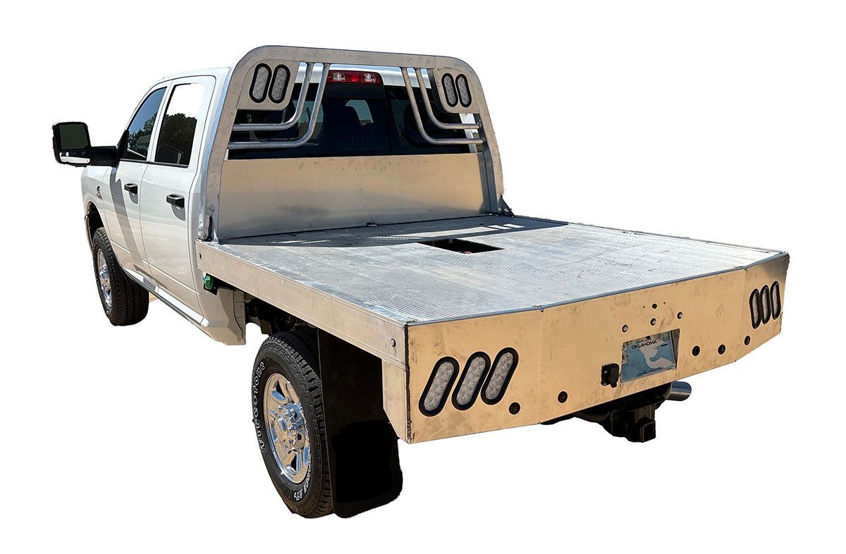 A white Ram truck with an aluminum flatbed on a white background.