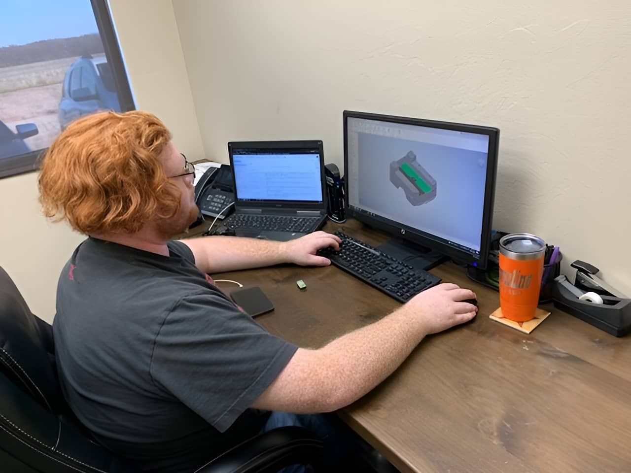 man working in Crownline office at computer desk