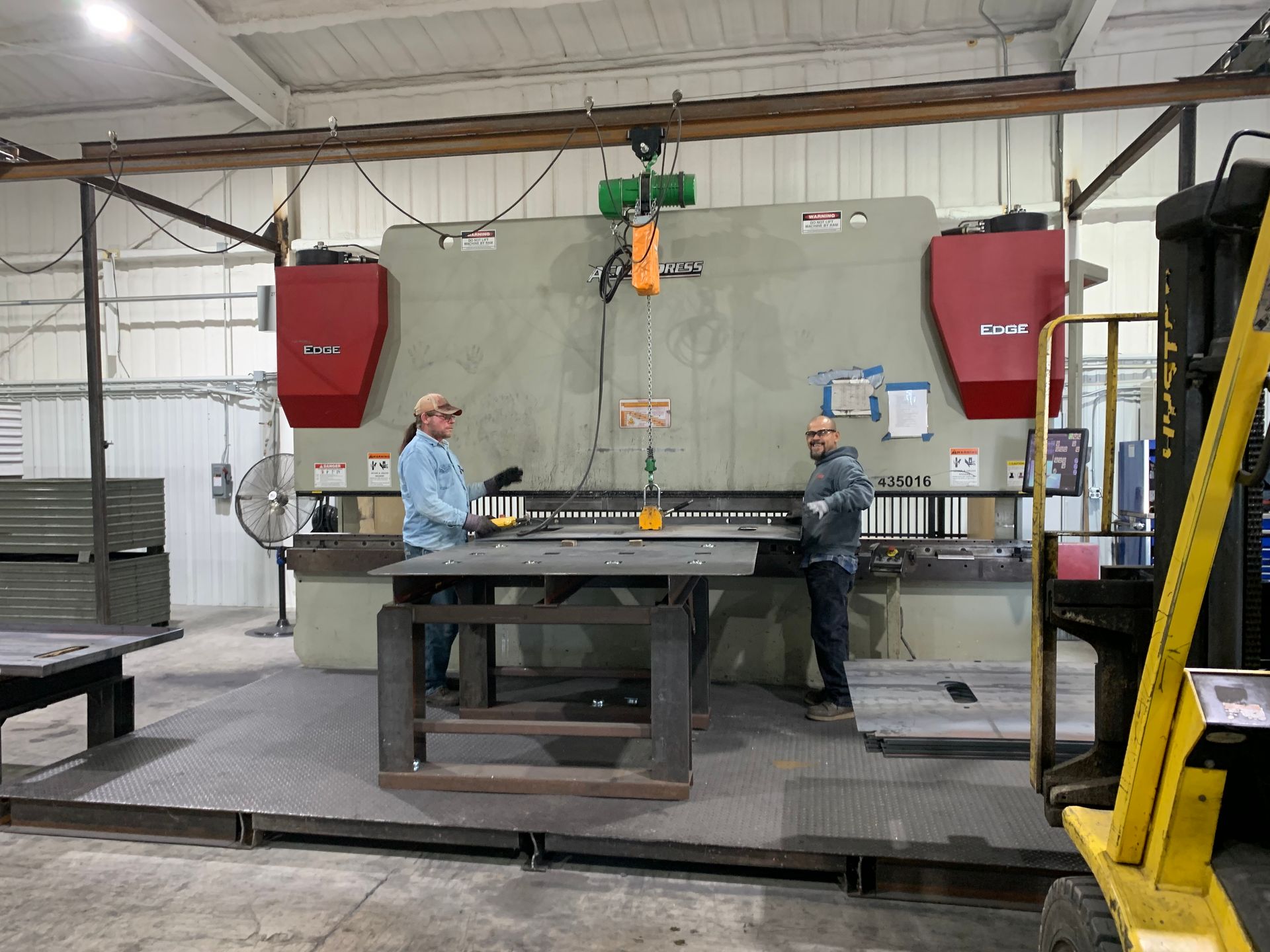 two men are working on a machine in a factory .
