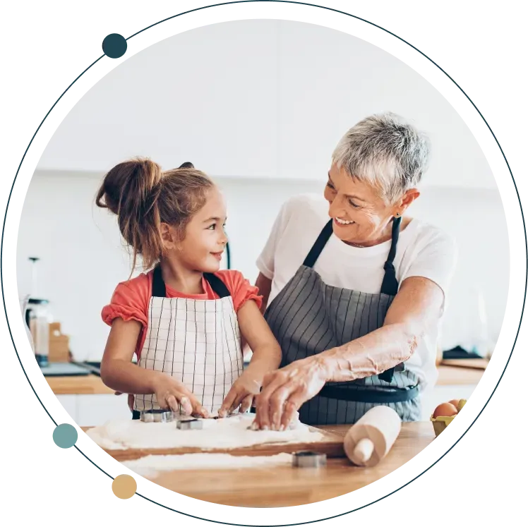 Grandmother and her granddaughter baking together in the kitchen.