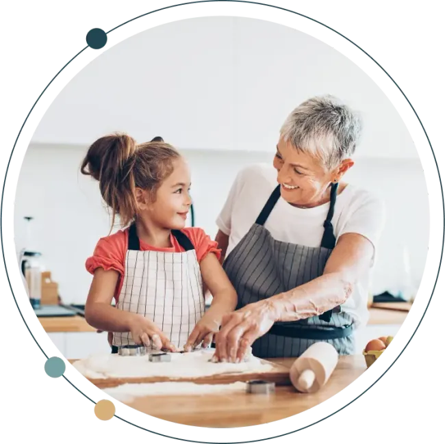 Grandmother and her granddaughter baking together in the kitchen.