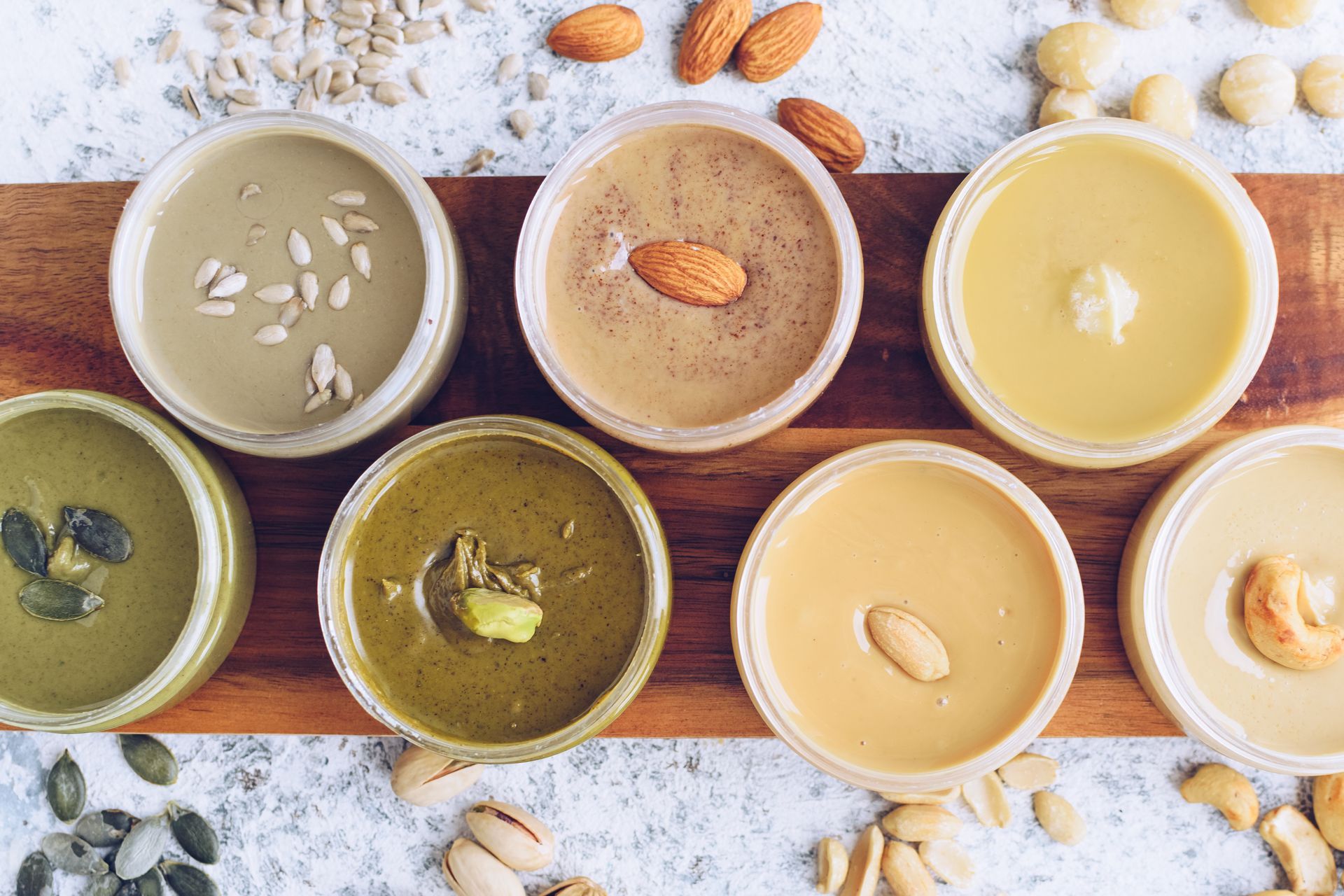 There are many different types of peanut butter on the table.