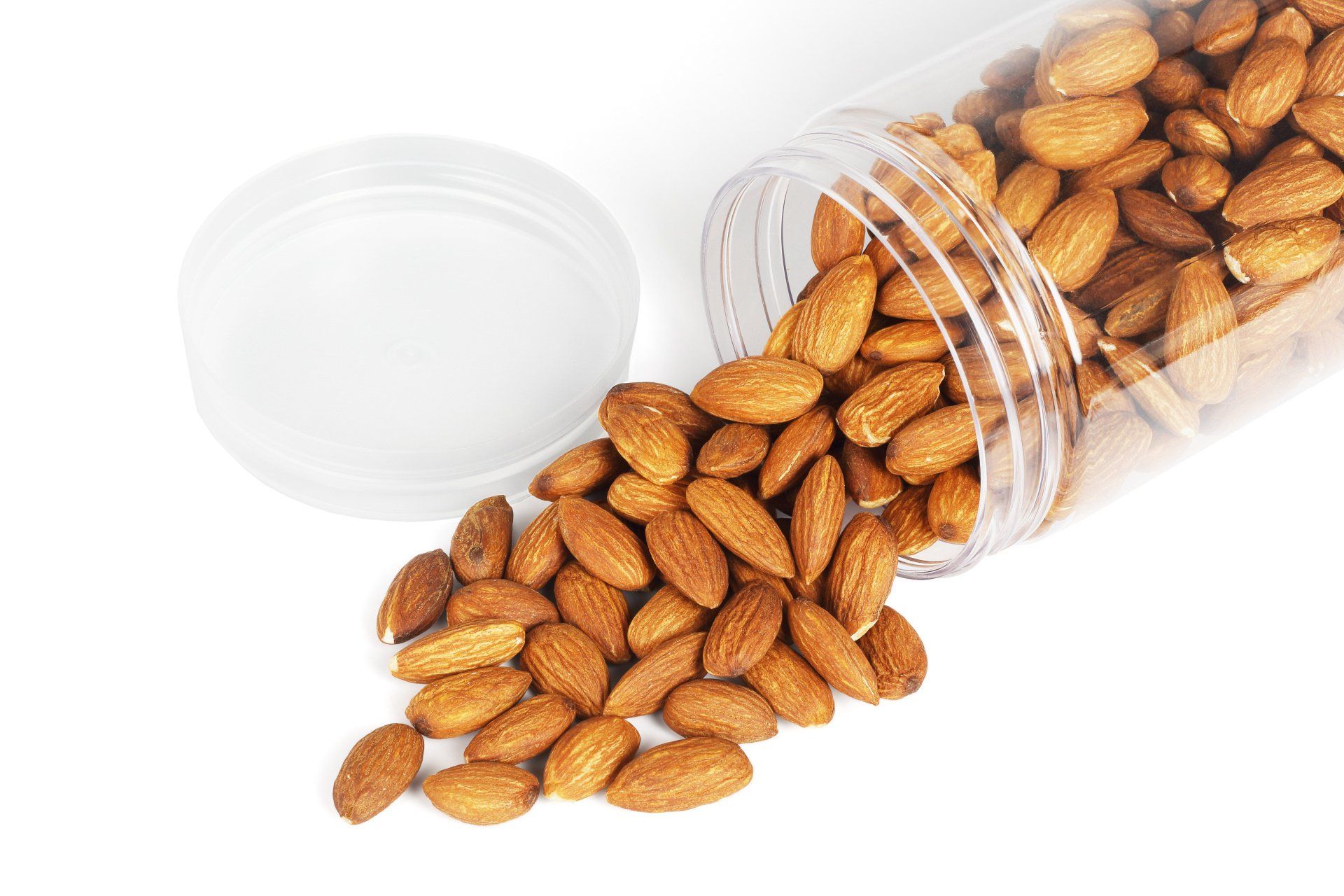 Almonds spilling out of a clear plastic jar.