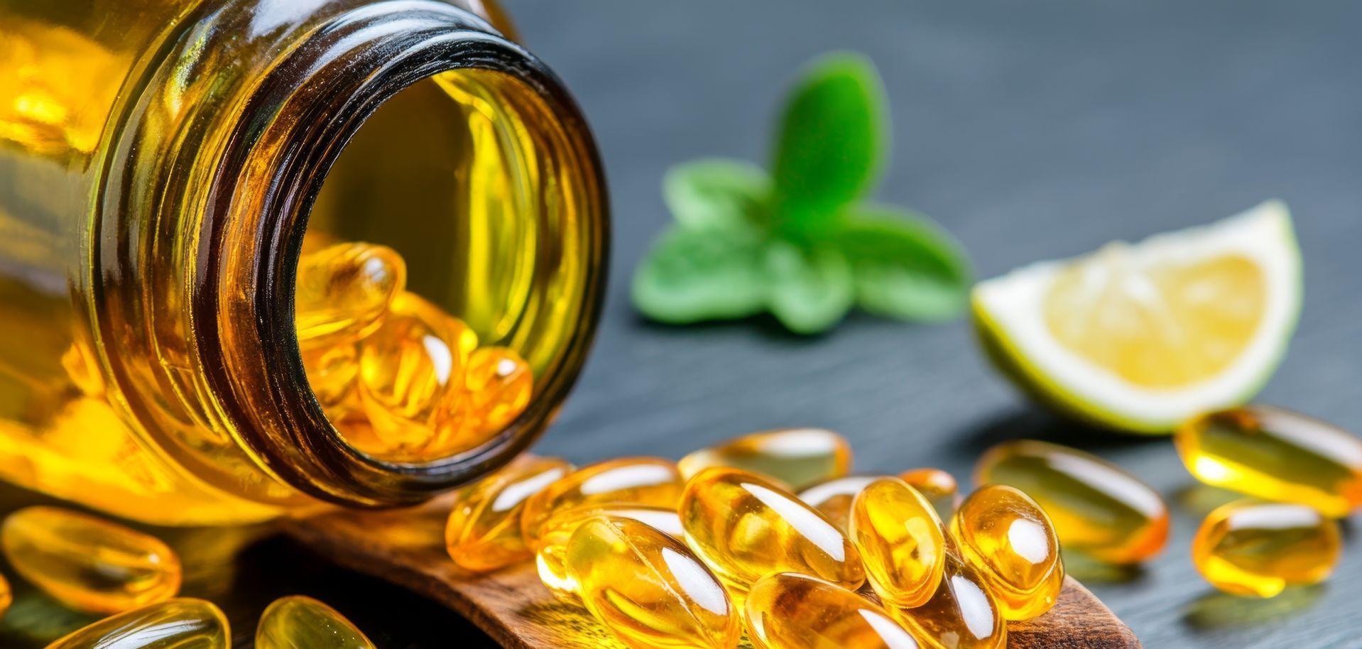 A bottle of fish oil capsules is being poured into a wooden spoon.