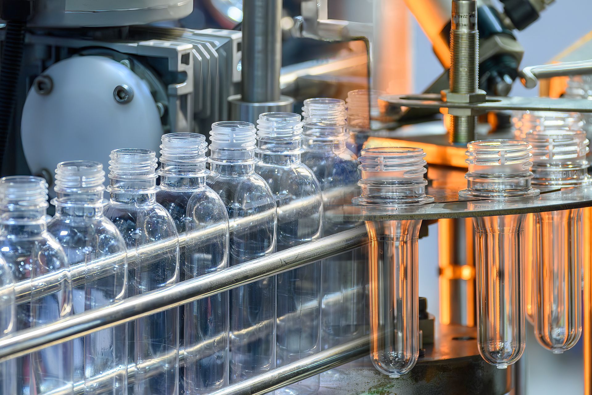 A conveyor belt filled with plastic bottles and test tubes in a factory.