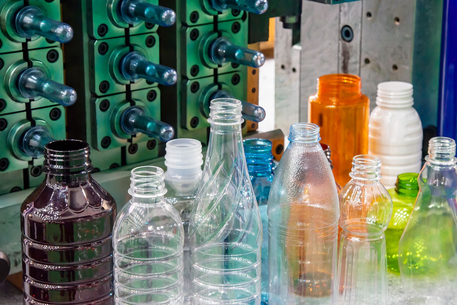 A group of plastic bottles sitting on top of a table next to a machine.