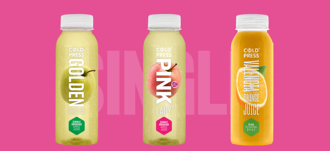 Three bottles of juice are sitting next to each other on a pink background.