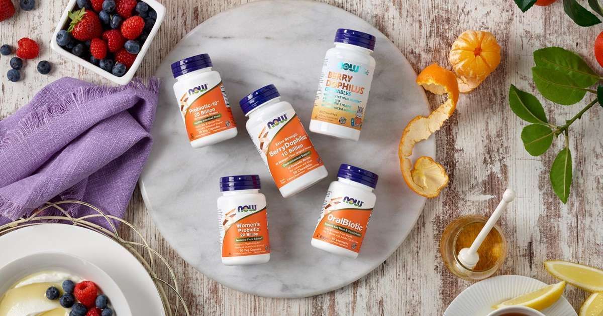 A table topped with bottles of vitamins and fruit.