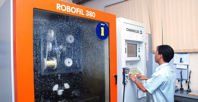 A man is working on a robotic machine in a lab.