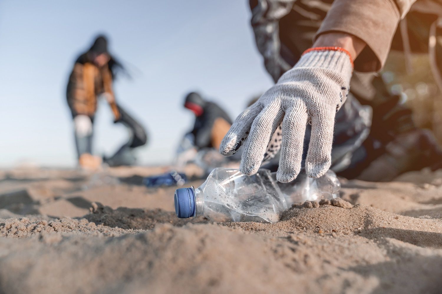 Volunteers cleaning up plastic pollution on the beach.