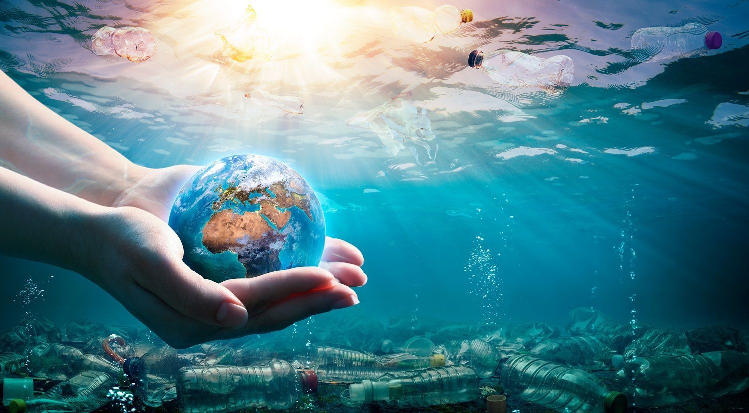 Planet Earth in protective cupped hands against a backdrop of plastic pollution in the ocean.