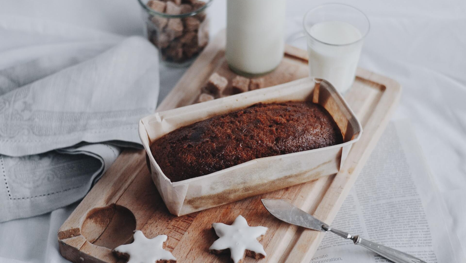 Gingerbread in a pan with two glasses of milk.