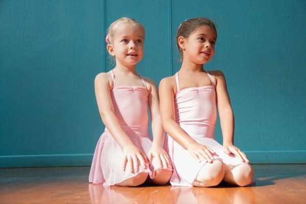 Two Young Girls in Pink Ballet Attire Kneel on Wooden Floor — Kay Flynn Dancing Academy Southport in Southport, QLD