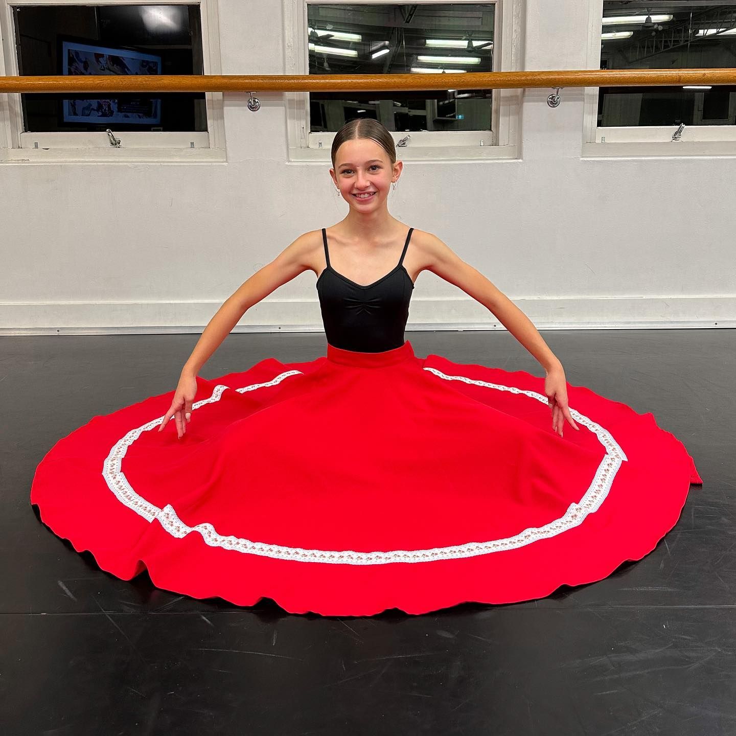 Young Dancer in a Red Skirt and Black Top, Seated on the Floor — Kay Flynn Dancing Academy Southport in Southport, QLD