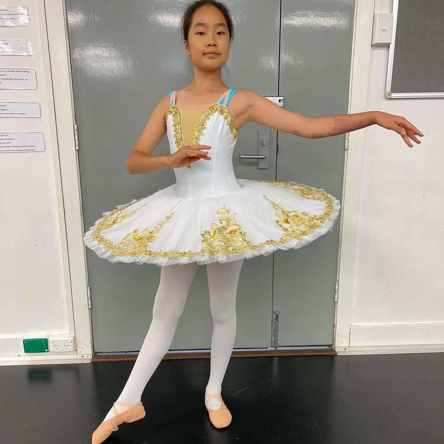 Young Ballerina in White Tutu, Gold Accents, and Pointe Shoes — Kay Flynn Dancing Academy Southport in Southport, QLD