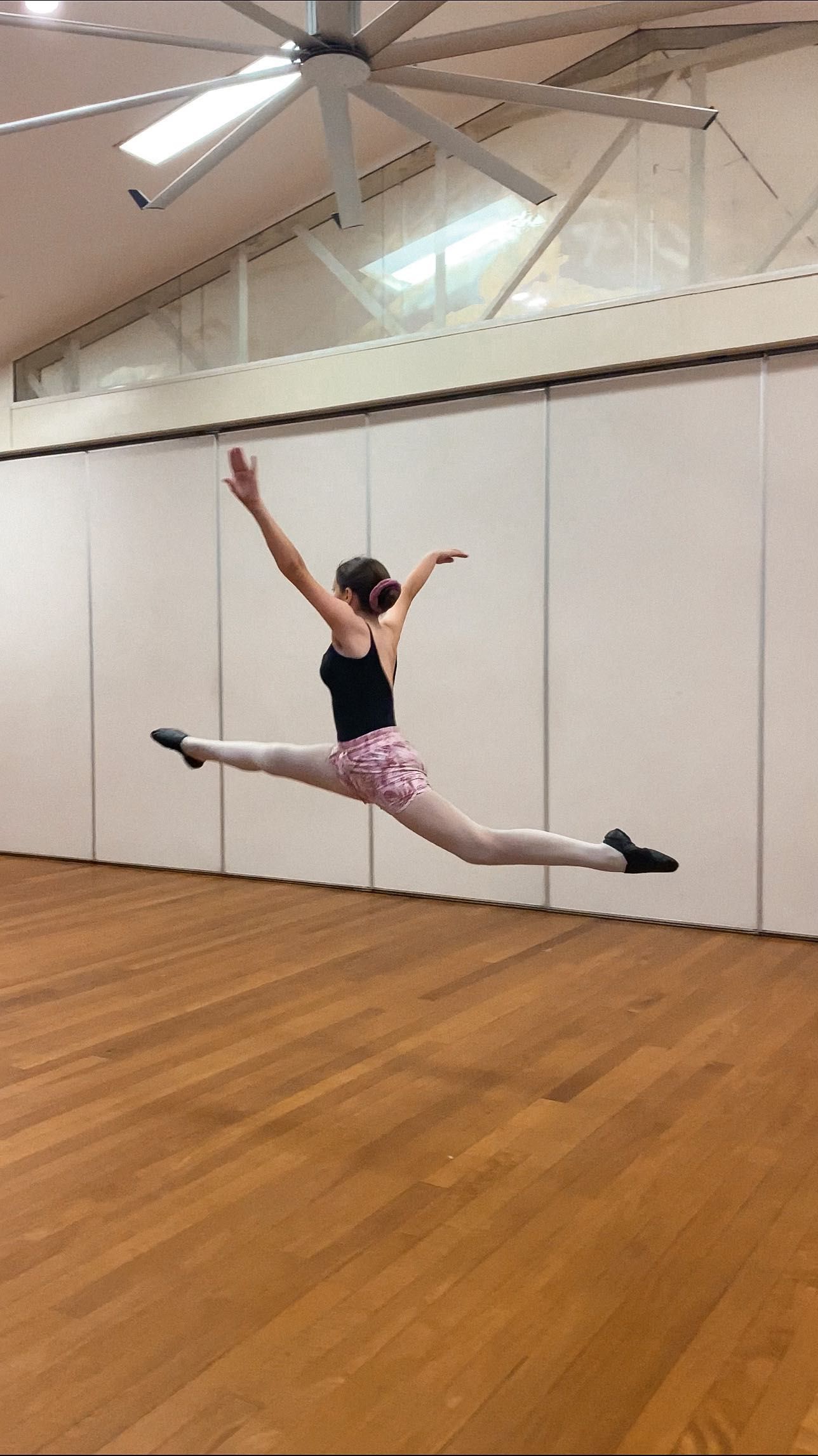 Dancer Leaping Mid-air in a Split, Arms Raised — Kay Flynn Dancing Academy Southport in Southport, QLD