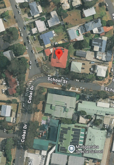 Aerial view of a neighborhood with residential houses and a school building. A red pin marks the location. — Kay Flynn Dancing Academy Southport in Southport, QLD