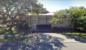 Two-story house with a balcony and garage entrance. Trees flank the driveway. — Kay Flynn Dancing Academy Southport in Southport, QLD
