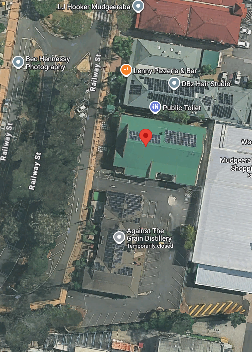 Aerial view of a building with a red location marker, near streets and other buildings, in a town. — Kay Flynn Dancing Academy Southport in Southport, QLD