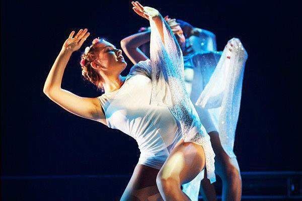 Dancers in White Costumes Performing on a Stage, Arms Raised — Kay Flynn Dancing Academy Southport in Southport, QLD