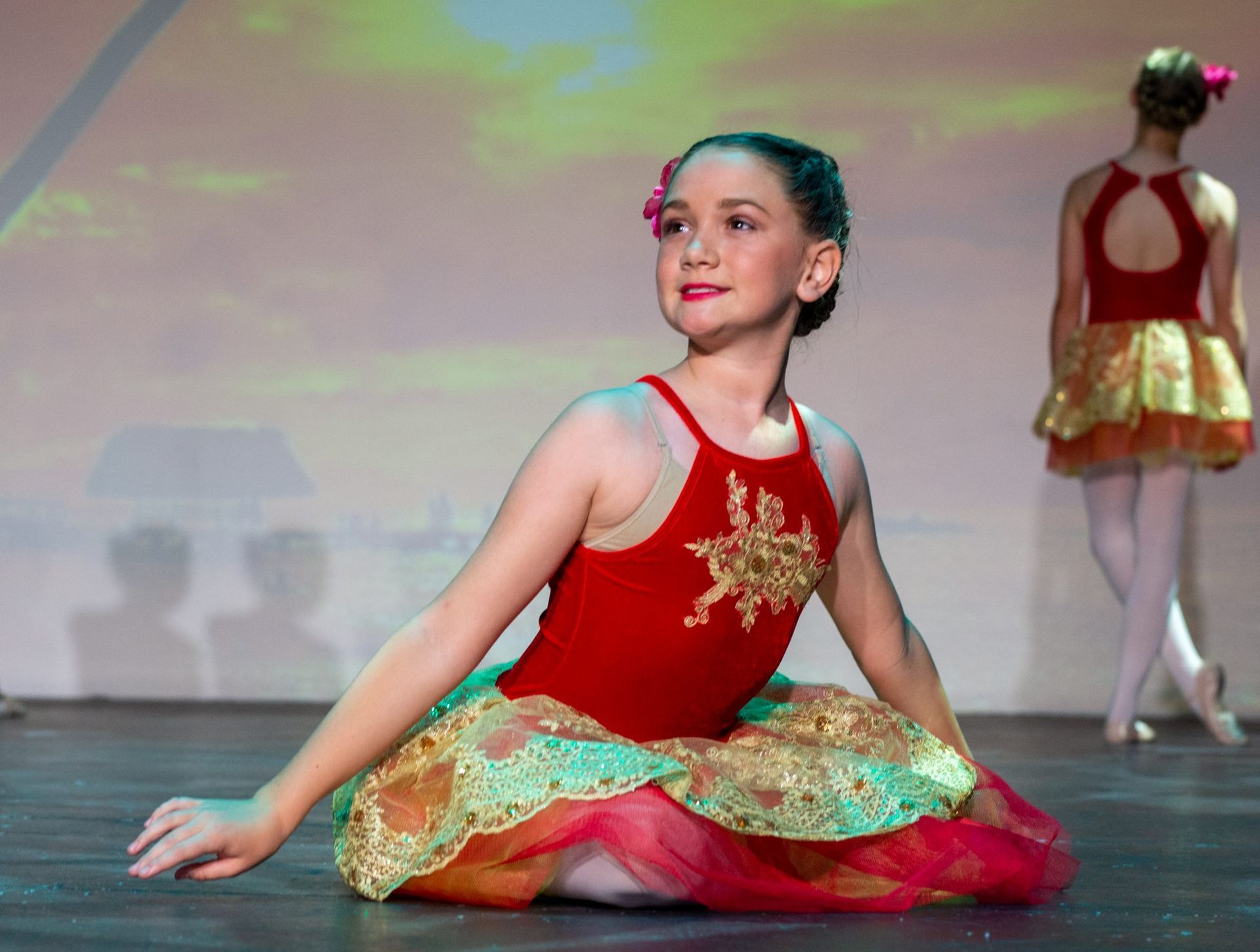 Young Ballerina in Red and Gold Tutu, Smiles on Stage — Kay Flynn Dancing Academy Southport in Southport, QLD