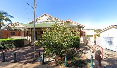 Tan building with green roof, porch, and a flagpole on a sunny day. — Kay Flynn Dancing Academy Southport in Southport, QLD