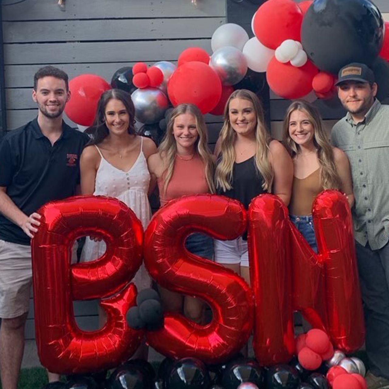 Group of people celebrating, posing with red
