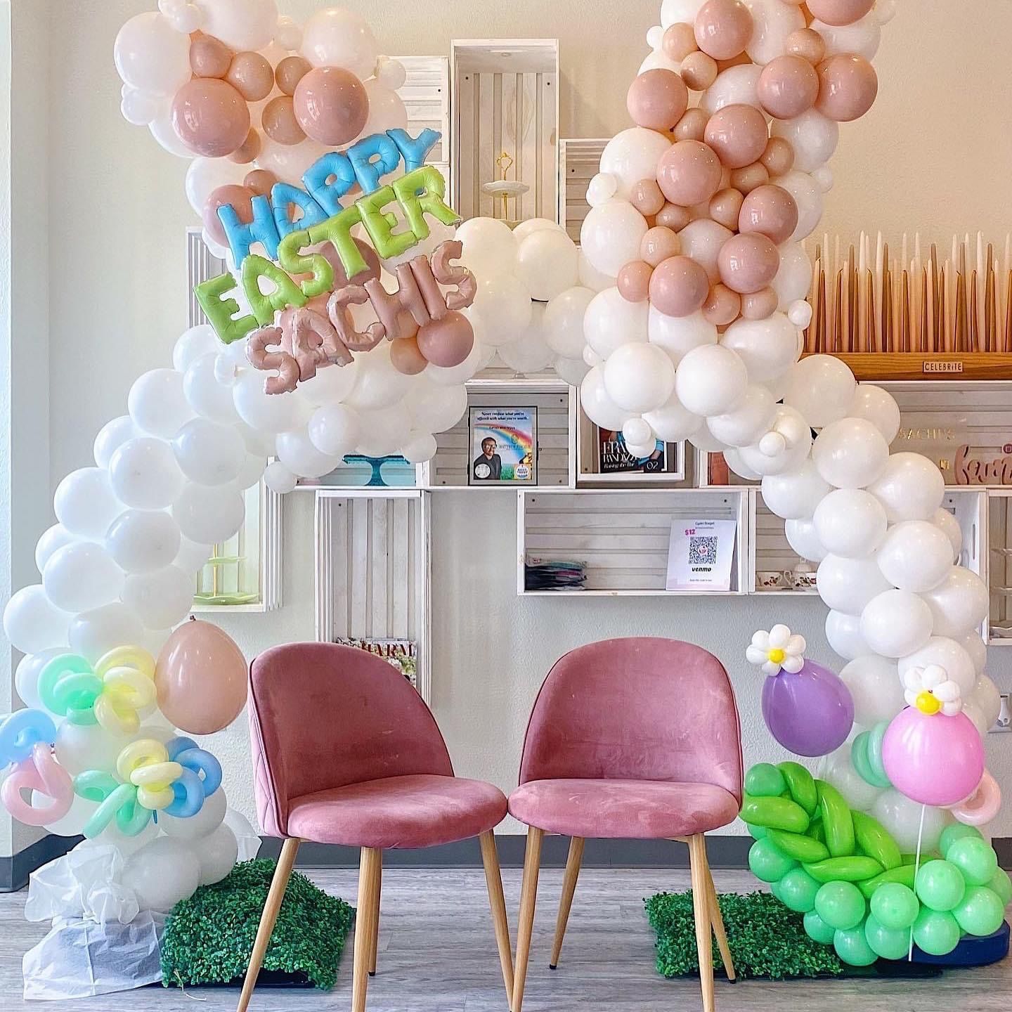 Easter balloon arch with pink chairs. 