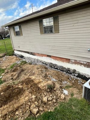 A house with a lot of dirt and rocks in front of it.