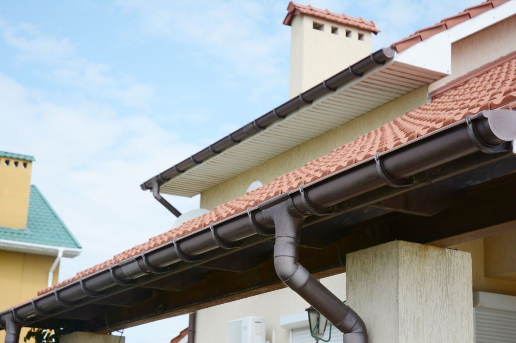 Image of  rain gutter with holders and downspout pipe