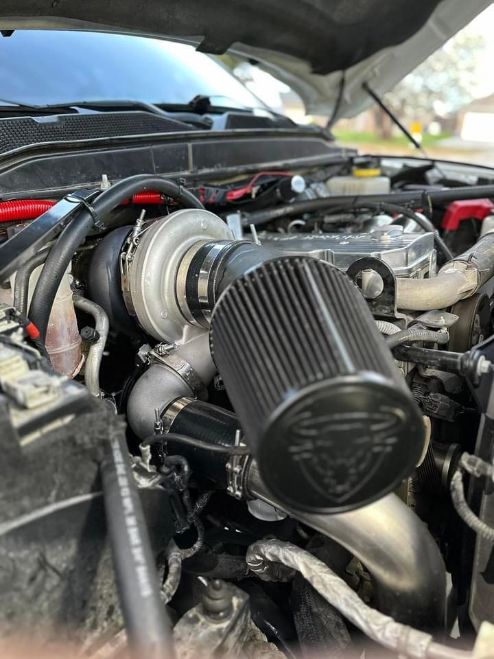 A close up of a car engine with the hood open.