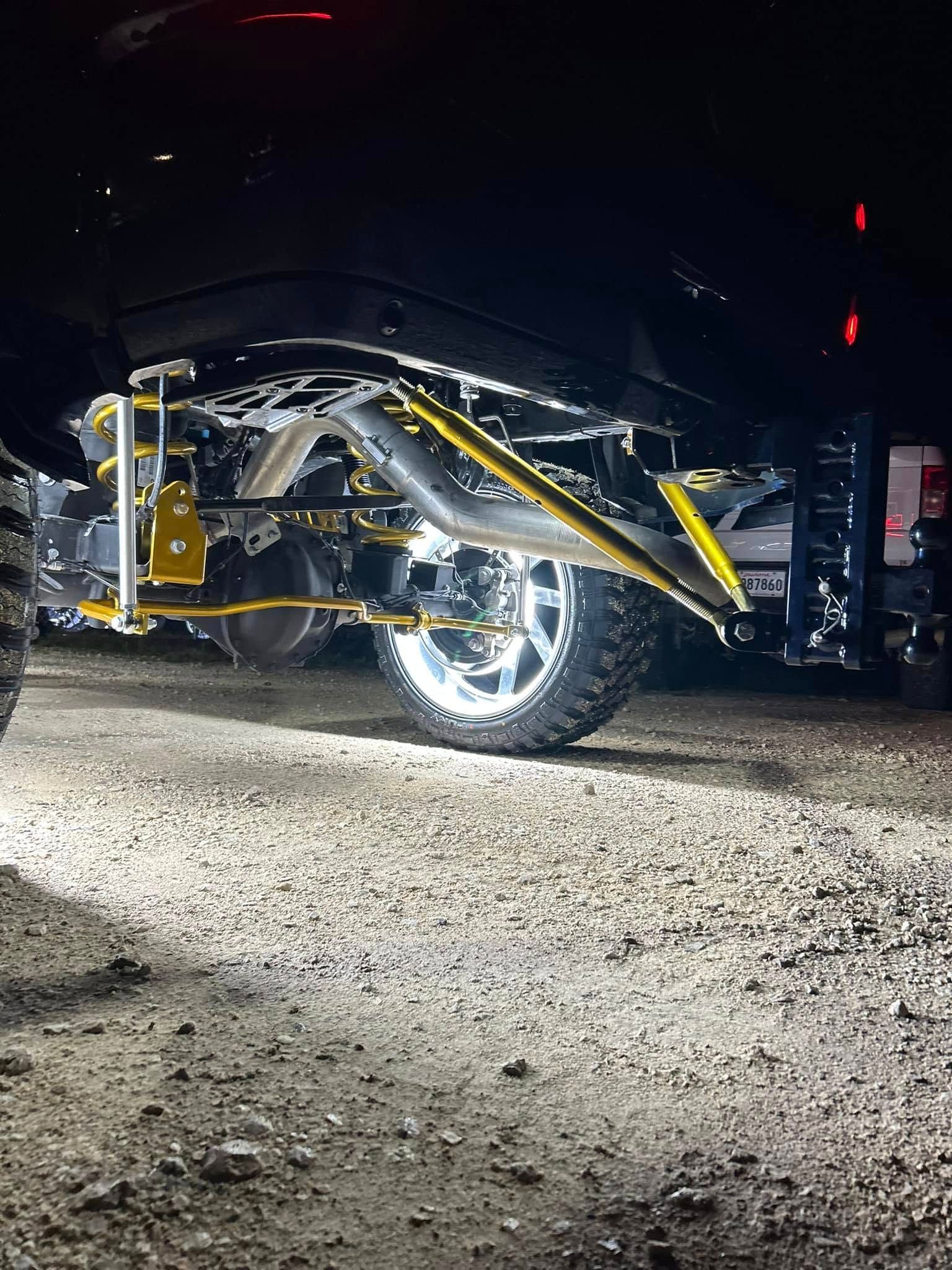 A truck is parked on a gravel road at night.
