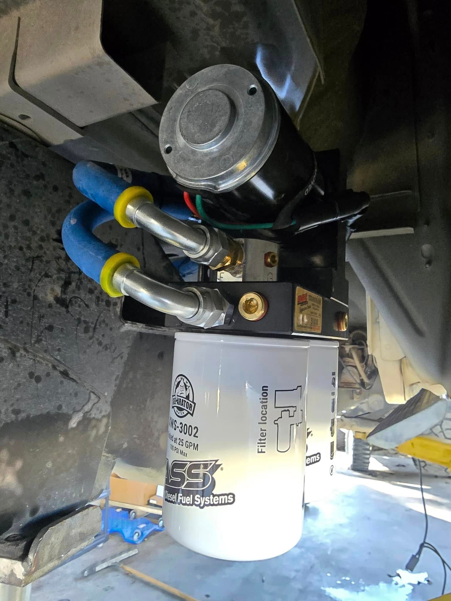 A close up of a fuel filter with hose attached to it.