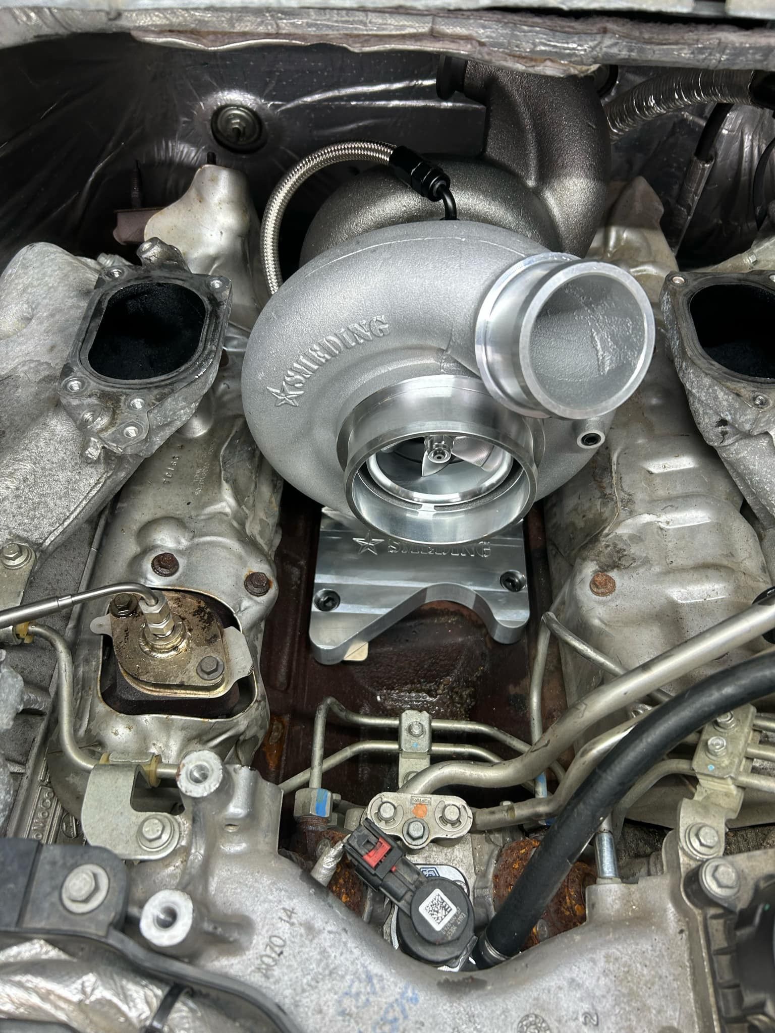 A turbocharger is sitting inside of a car engine.